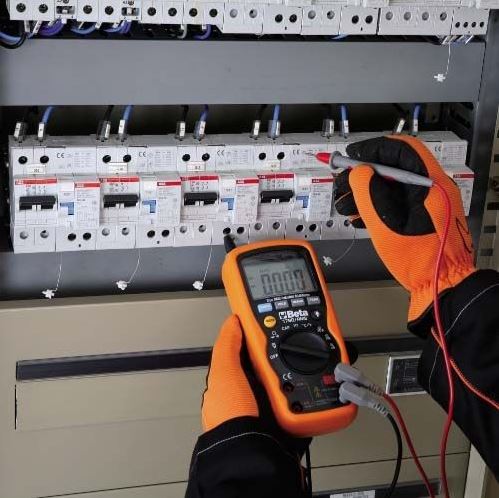 Electricien se servant d'un multimètre sur le compteur électrique